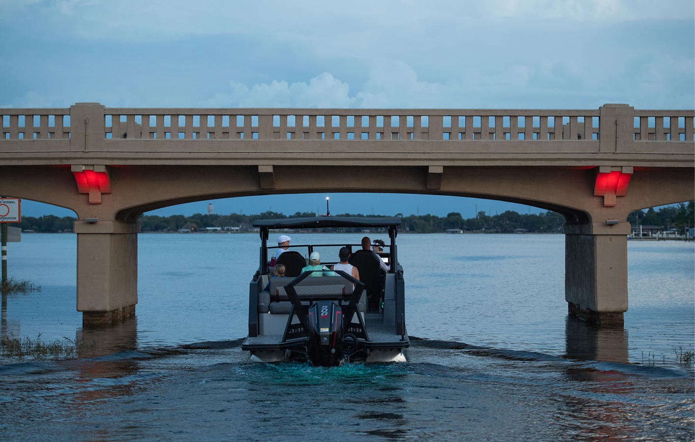 A boat navigates beneath a bridge, showcasing the connection between water and land.