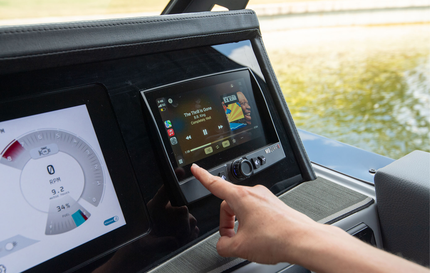 A man operates a tablet to navigate a boat, showcasing modern technology in marine control.