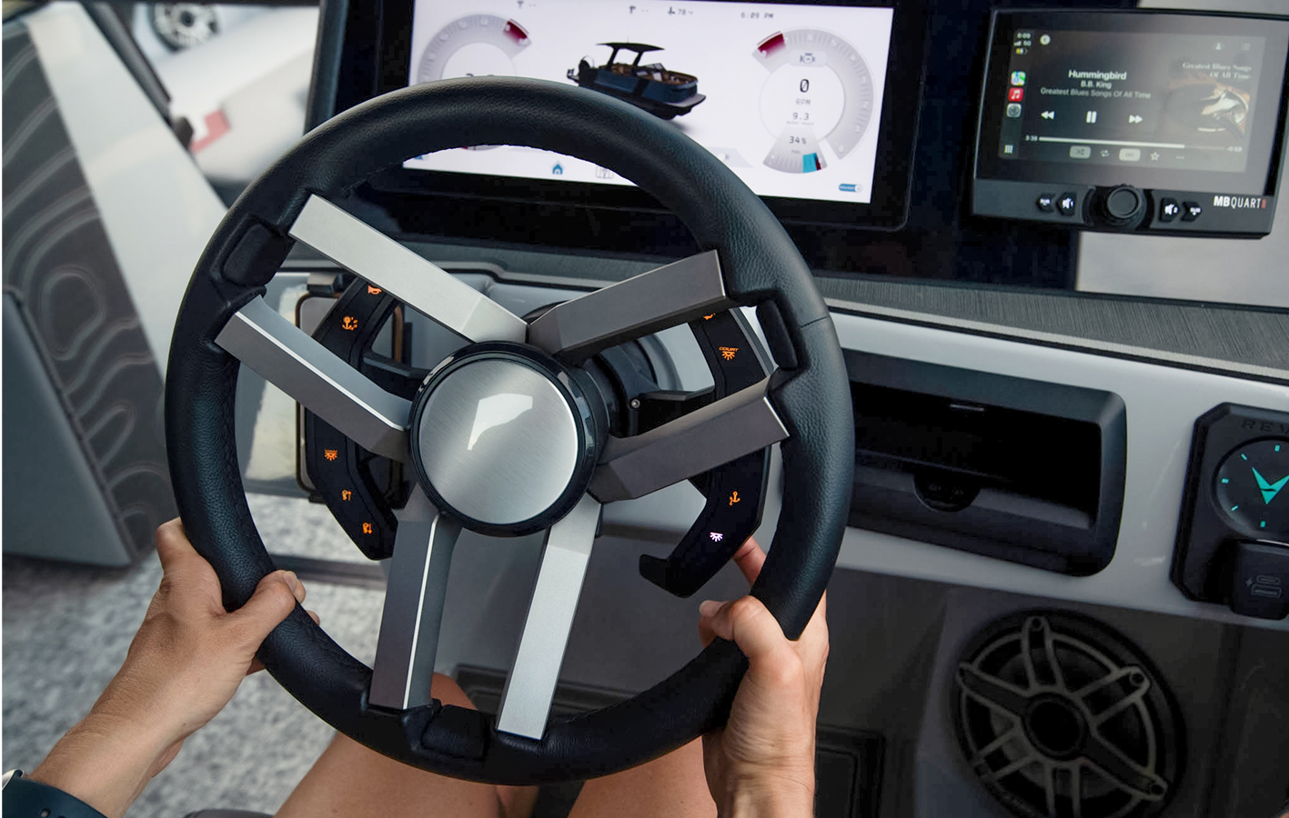 A family enjoys a sunny day riding on a pontoon boat, surrounded by calm water and a clear blue sky.
